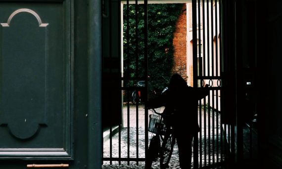 person standing in front of black metal gate